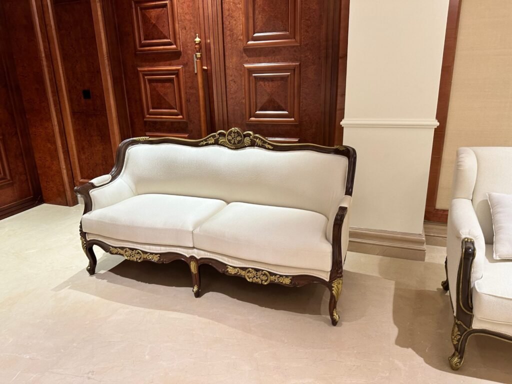 Hand carved two seater sofa with gilded crest and ivory upholstery by Morbagh Designs