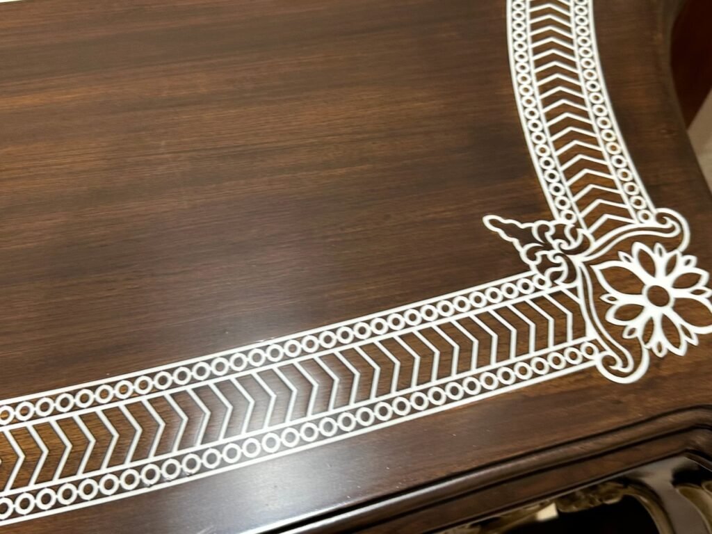 Close up of hand laid white inlay border with chevron and floral corner on a Morbagh table top